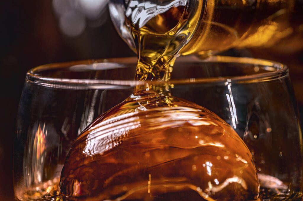 nalewanie whisky do szklanki z lodem
